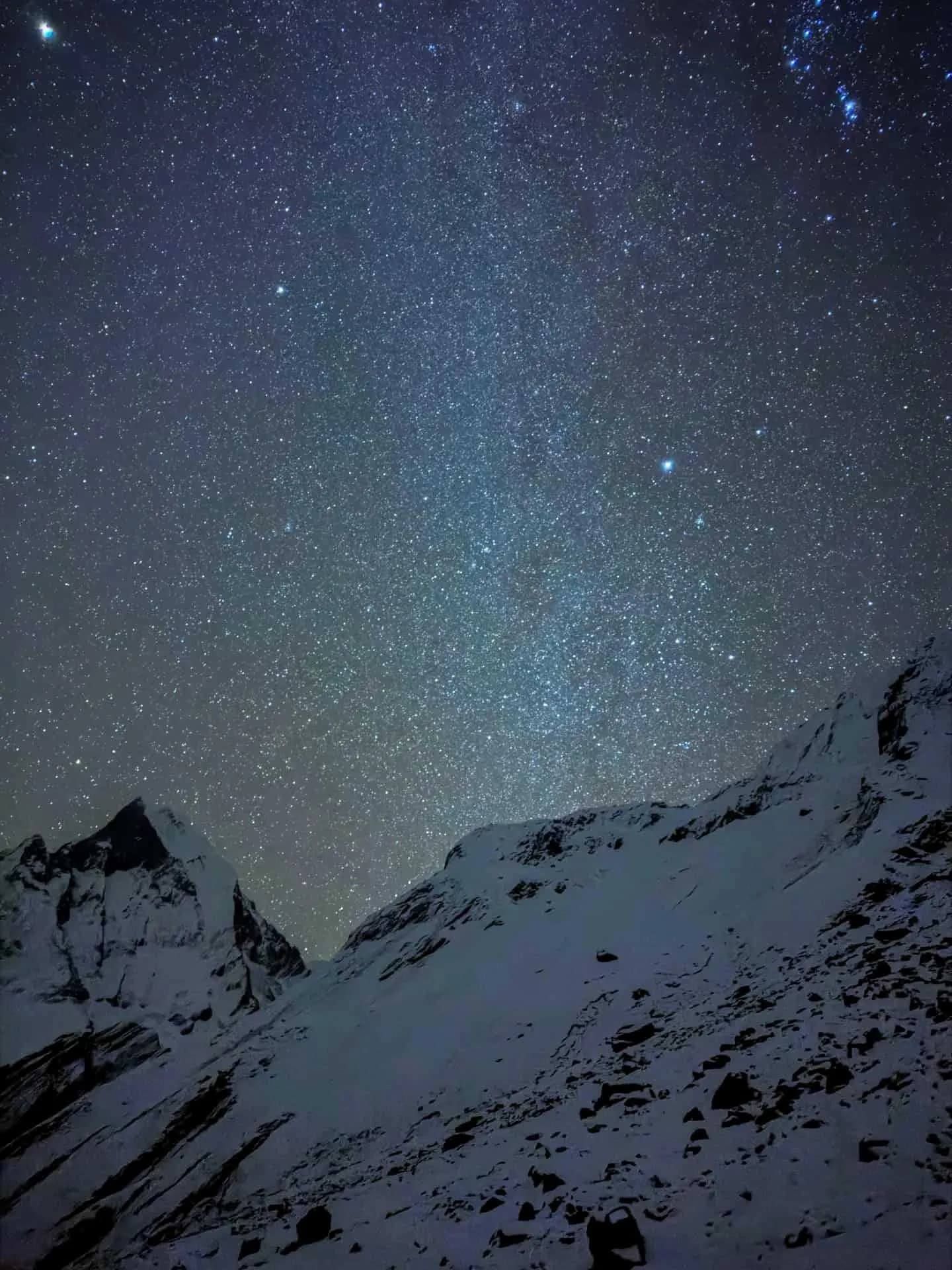 Star-filled night sky above snowy Himalayan mountains near Annapurna Base Camp