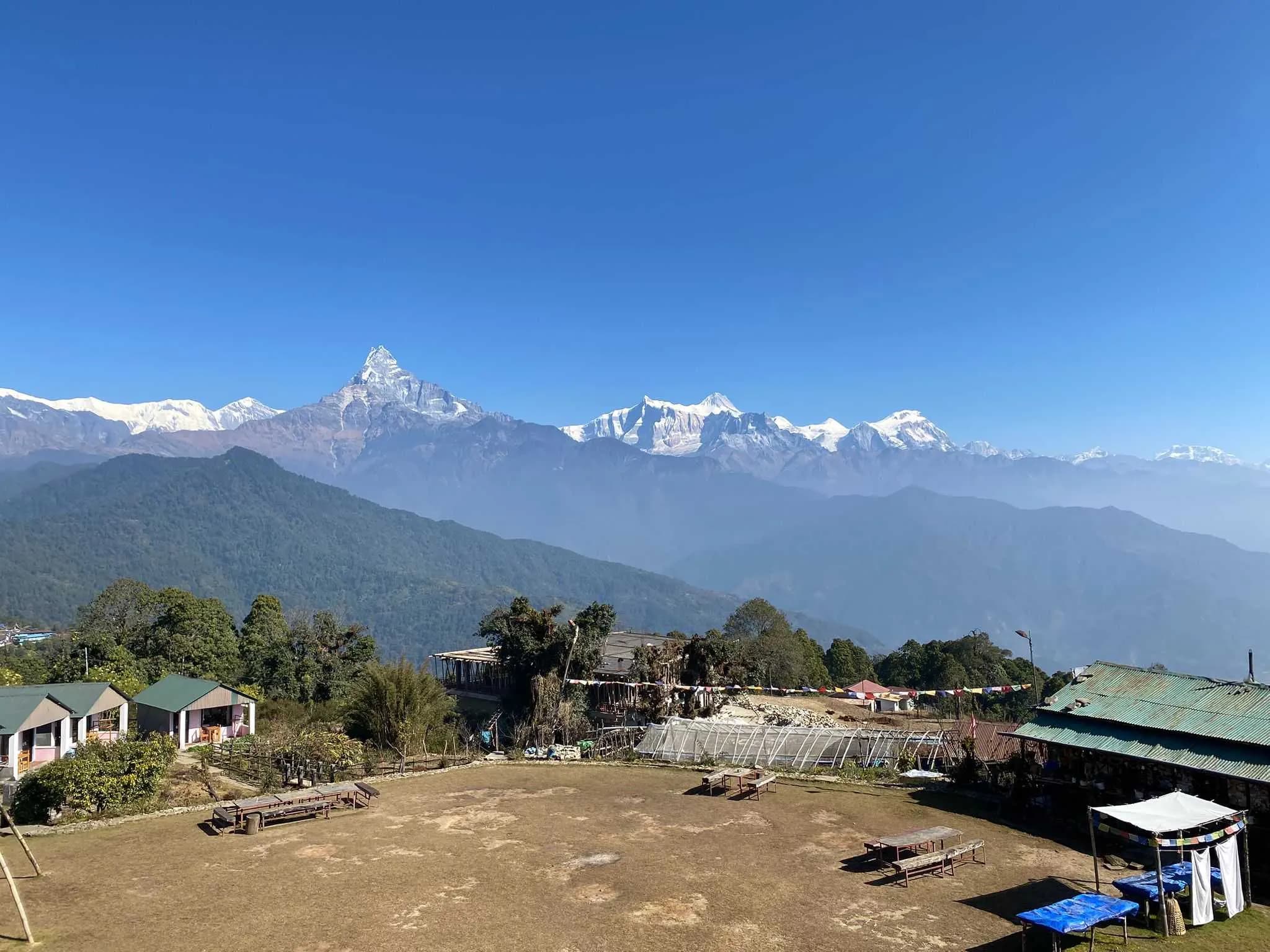 Stone walkway with flowers and potted plants facing snowy mountain peaks on the Australian Base Camp trail